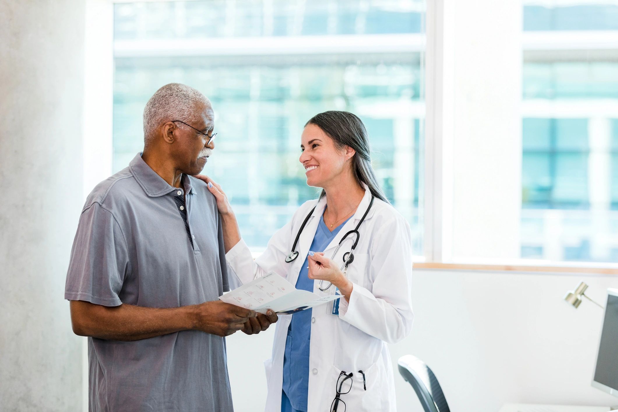 Doctor smiling and reassuring a senior patient during a consultation